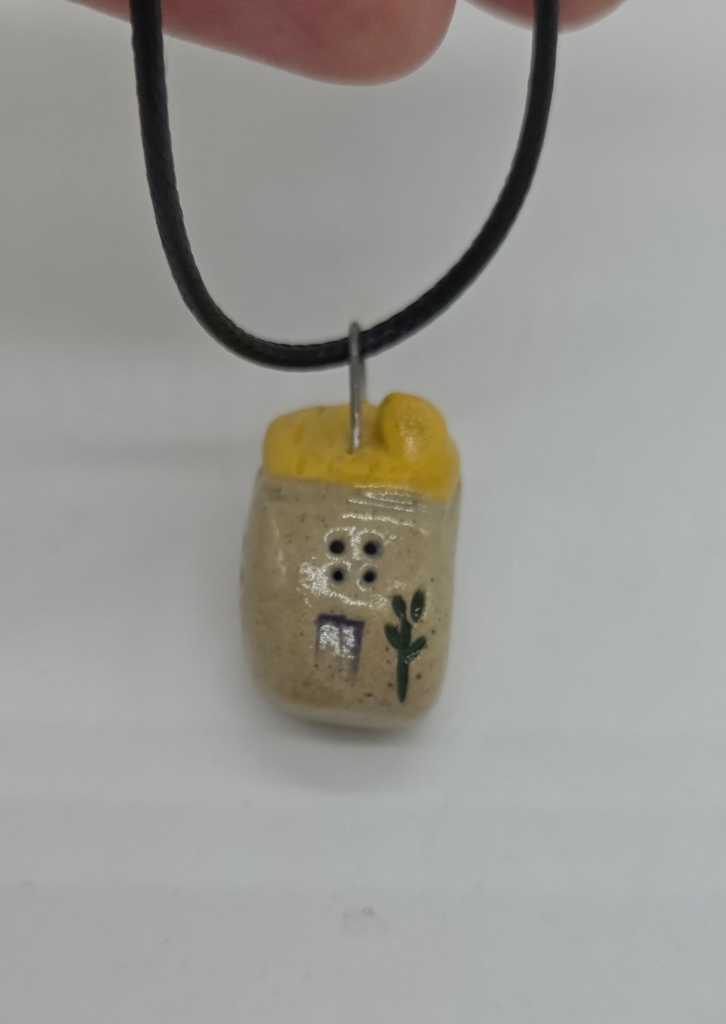 Yellow Tiny House Pendant on black waxed cotton necklace