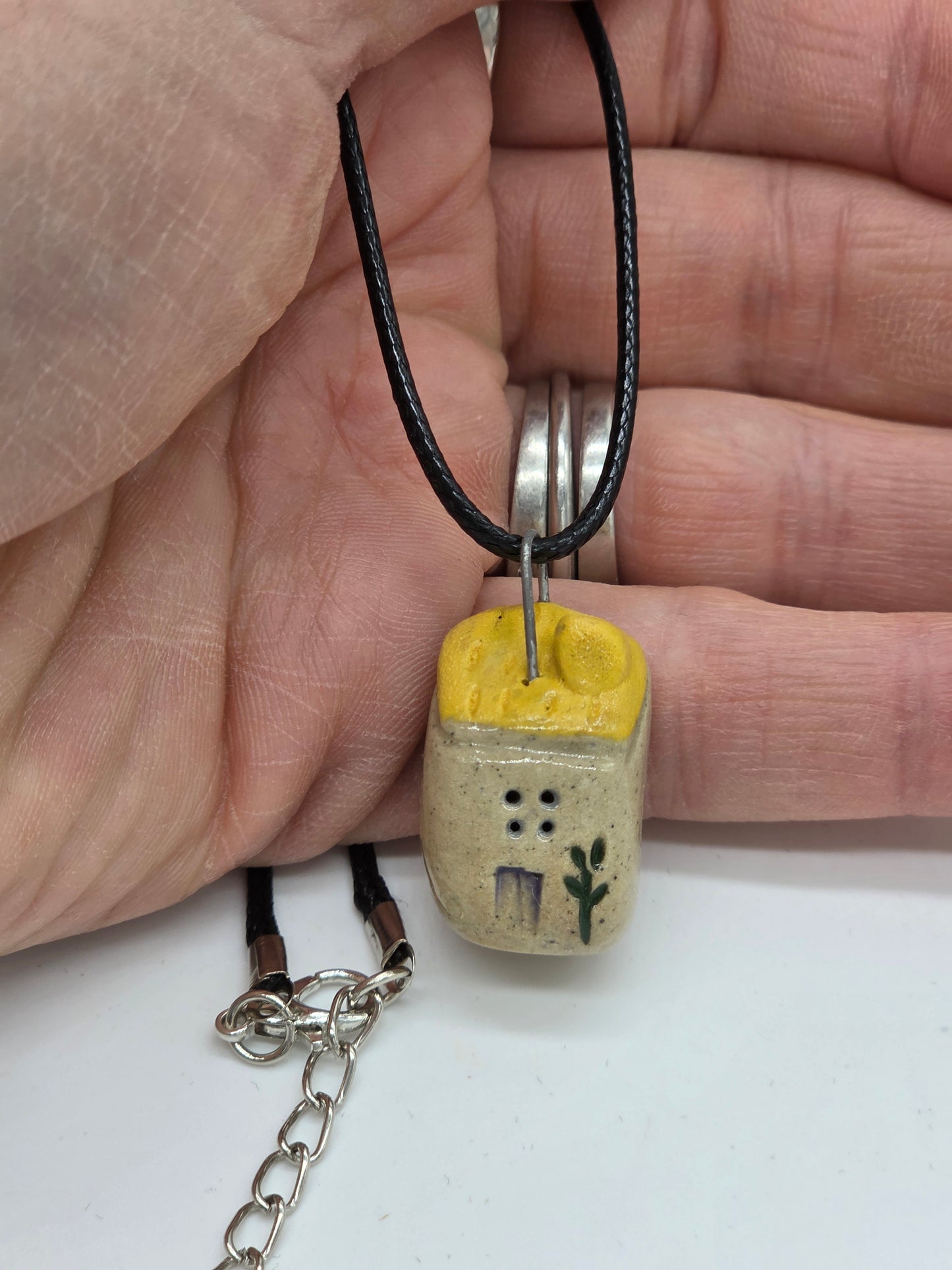 Yellow Tiny House Pendant on black waxed cotton necklace